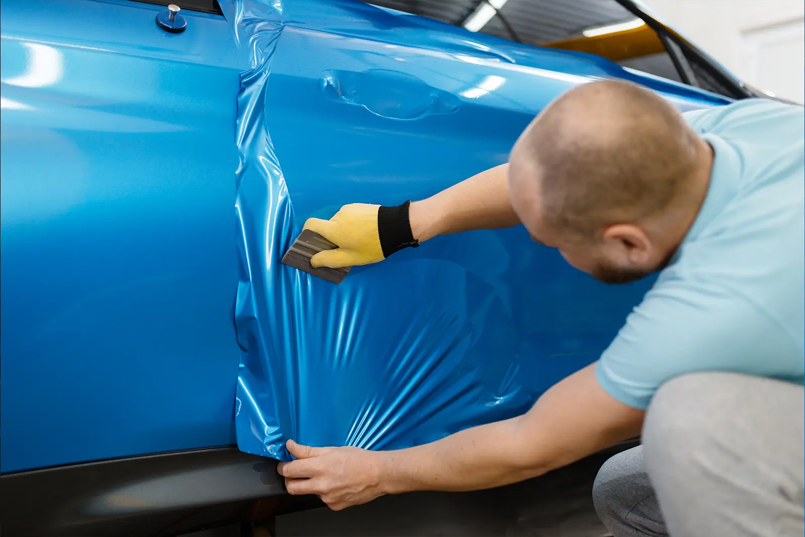 Autofolierung wird auf Fahrzeugtür aufgebracht
